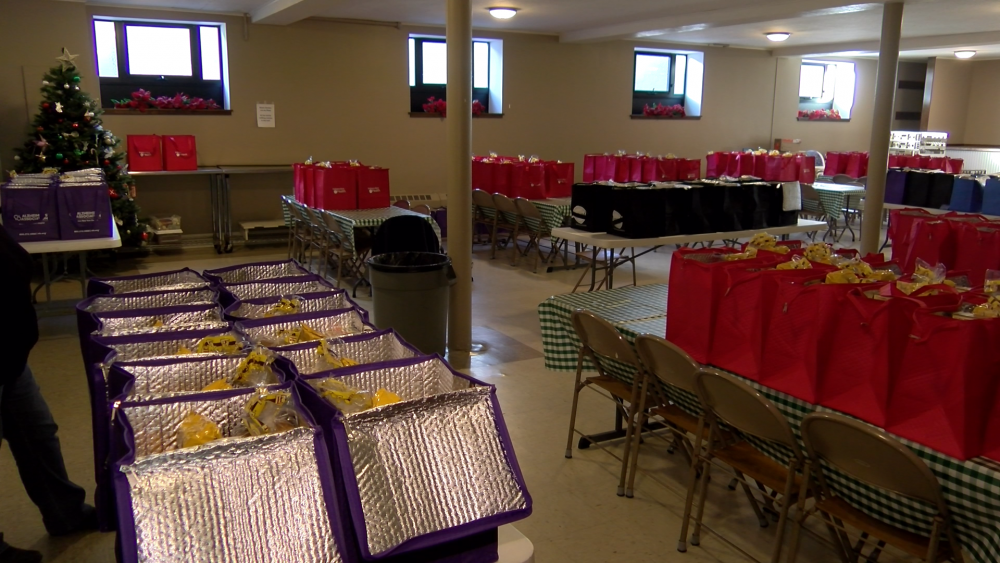 Community members at Hurlbut Memorial Community United Methodist Church prepare holiday meals as part of the annual "Santa for Seniors" campaign, providing nourishment and joy to isolated older adults.